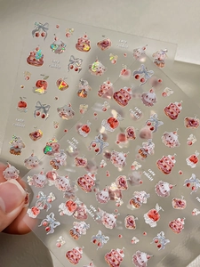 Makro-Detail von Laser-Glitzer-Nagelaufklebern mit süßen Hasen und roten Kirschen