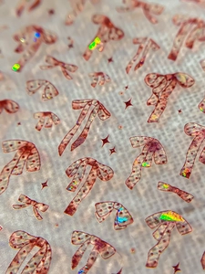 Macro shot of 3D pink gold bow nail stickers with laser glitter and star sequins