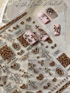 Macro view of leopard print nail stickers with silver crosses and Y2K aesthetic designs