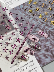 Detail view of leopard print star nail stickers with pink and gold metallic finish accents