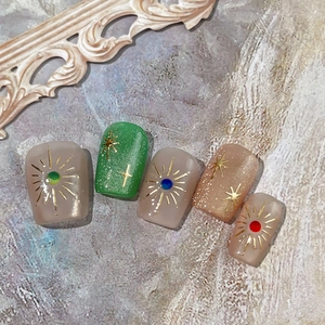 Bohemian style press-on nails set with star patterns and sunburst art in earthy tones