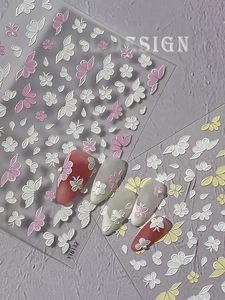 Detail view of 3D embossed floral nail stickers featuring pink butterflies and petals