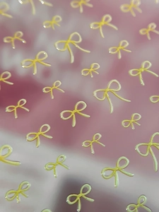Vue macro de stickers nail art nœuds jaunes en relief 3D avec texture brillante