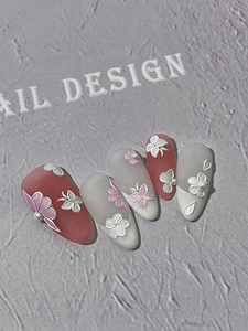 Detailed view of 3D embossed floral nail stickers in matte white and pink colors