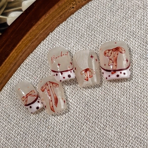 French press-on nails featuring red bowknots and polka dots on creamy white base