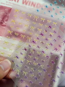 Détail des stickers d'ongles en relief 3D avec nœuds colorés et texture brillante