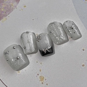 Bow tie nail stickers with metallic beads and silver glitter on milky white press-on nails