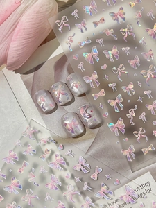 Detailed holographic bow nail art stickers featuring gradient metallic 3D relief effects