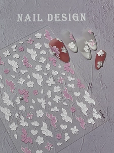 Detailed macro view of 5D embossed nail art stickers featuring pink and white floral butterfly