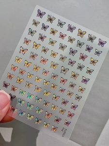 Detailed macro view of holographic butterfly nail art stickers in iridescent finish