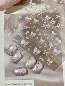 Detailed macro view of 3D aurora bow nail art stickers with iridescent heart and star patterns