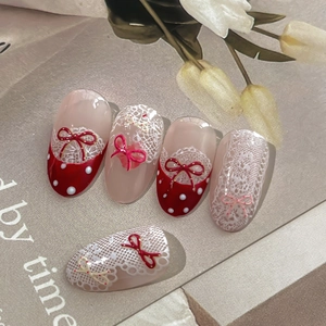 Handmade red French press-on nails with white lace patterns and 3D bow decorations