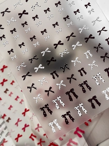 Detailed view of polka dot bow nail stickers with black and white elegant designs