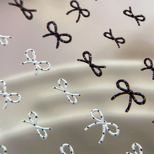 3D embossed nail art stickers featuring black bows and white polka dot patterns