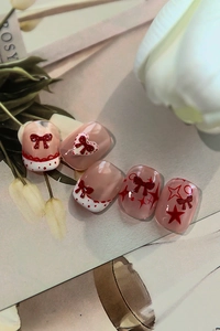 Close-up of red 3D bow and heart relief nail art with French polka dot patterns