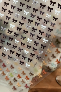 Macro shot of 5D embossed bow nail stickers featuring detailed textures and 3D relief effects