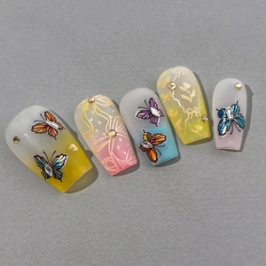 Vibrant butterfly press-on nails with colorful gradients and rhinestones for summer