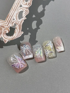 Detailed macro of pink and green gradient hand-painted butterfly press-on nails with glitter