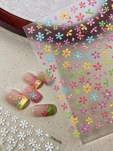 Détail macro de stickers ongles 3D en relief avec motifs floraux colorés variés