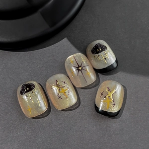 Faux ongles œil de chat avec motifs de nuages et étoiles noirs et champagne