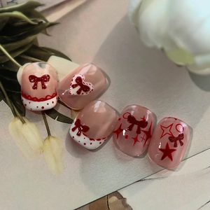 Pink and red press-on nails featuring 3D bow ties, heart patterns and dot designs