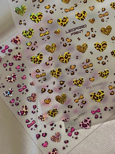 Close-up of leopard heart nail stickers with holographic glitter and bow patterns