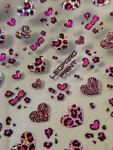 Macro detail of pink leopard heart nail stickers with glitter and holographic finish