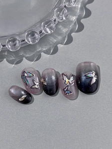 Detailed view of cat-eye gradient butterfly press-on nails with rhinestone accents