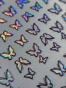 Macro shot of holographic butterfly nail art stickers with laser glitter effect
