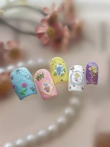 Detailed close-up of 3D embossed floral nail art press-ons in macaron pastel colors