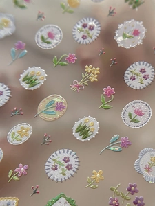 Close-up of 5D embossed floral nail art stickers with tulips and 3D textured flowers