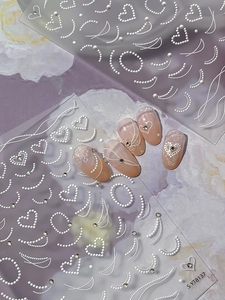 Detail of 5D embossed heart and pearl nail art stickers with 3D relief texture design