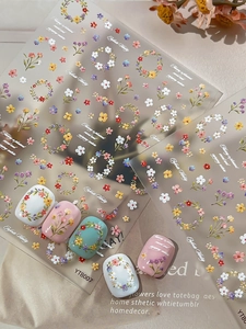 Close-up of 5D floral nail art stickers with relief texture and mixed color flower wreaths
