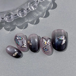 Gradient nail stickers with holographic butterfly and sparkling rhinestones on grey