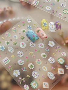 Detailed view of 3D embossed floral nail stickers with birds and ribbons on nails