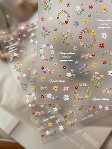 Macro detail of 3D embossed spring floral nail stickers with dainty flower garland patterns
