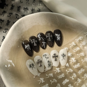 Gothic press-on nail set featuring black and white bowknots with silver cross charms
