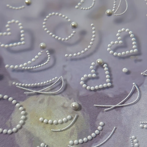 3D heart and floral relief nail stickers with white pearl accents on purple background