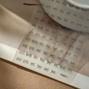 Close-up of black line bow nail stickers with YT493-1 code on elegant textured background