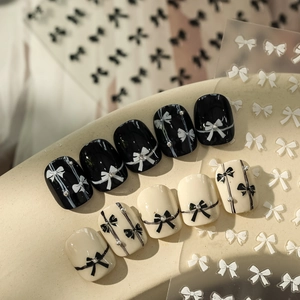 Detail of bow-knot nail stickers with micro pearls and black-white French style design