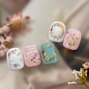 Floral embossed nail stickers with colorful flower wreaths on white and pink bases
