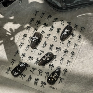 Detail of YT486 bow and cross nail stickers applied on black nails with shadow effect