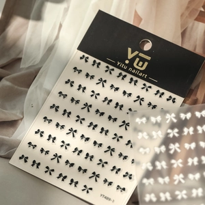 Detail view of black bow nail art stickers with elegant ribbon designs on YT489 packaging