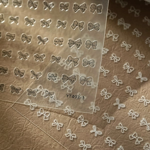 Macro detail of black and white bow nail stickers YT493 with adhesive backing for DIY manicure
