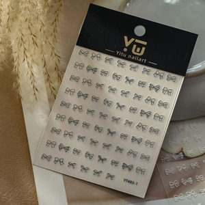 Detailed view of black and white bow nail art stickers with elegant floral background