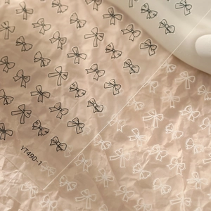Gros plan détaillé des autocollants pour ongles YT490-1 avec nœuds noirs et blancs mignons