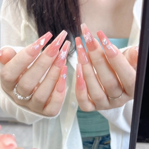 Detailed view of long coffin nails featuring pink gradient and 3D floral pearl accents
