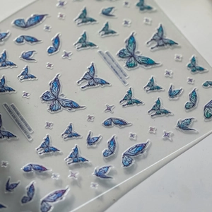 Blue and purple butterfly embossed nail stickers with glitter and cross star designs