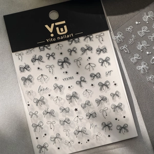 Close-up of 5D embossed nail stickers featuring black bows, stars, and lace patterns