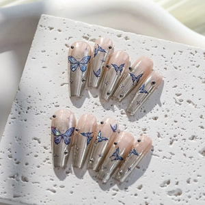 Detail of blue butterfly embossed nail stickers on metallic silver gradient long coffin nails